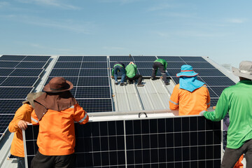 Workers install solar panels on a rooftop in a project during the day in a sunny outdoor setting with clear skies