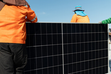 Workers install solar panels on a roof in a sunny location during the day