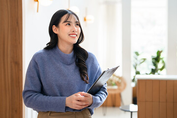 Young business woman freelancer holding document flie standing in cafe. © Fahng