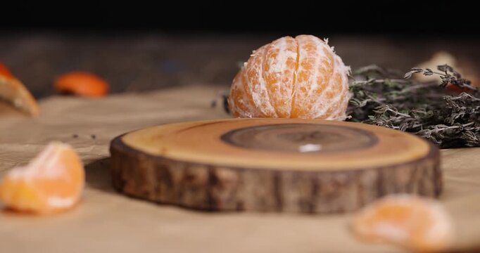 fresh white soft cheese with white mold lies on a wooden board on crumpled yellow paper, soft round cheese and sweet orange tangerines