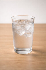 Glass of Cold Water with Ice on Wooden Table