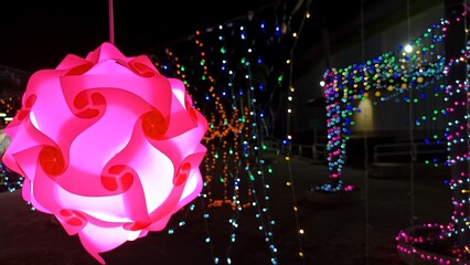 Radiant Light Artistry: Illuminated geometric shapes and strings of vibrant lights cascade across the night sky, creating a dazzling spectacle of color and form.