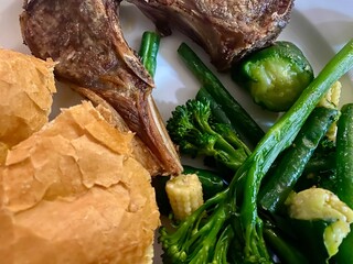 Grilled loin chops, green vegetables and bread rolls for supper
