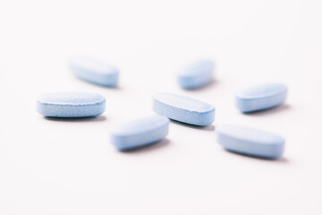 Multivitamin tablets on bright paper background. Close up. Copy space