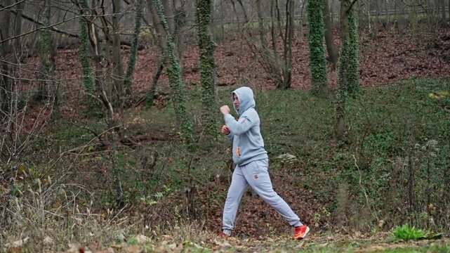 Practicing Boxing Alone In Forest Surroundings, Solitary Boxer Prepares With Controlled Moves Amidst Nature, An Individual Trains Alone Using Precise Boxing Techniques In Quiet Woodland Area