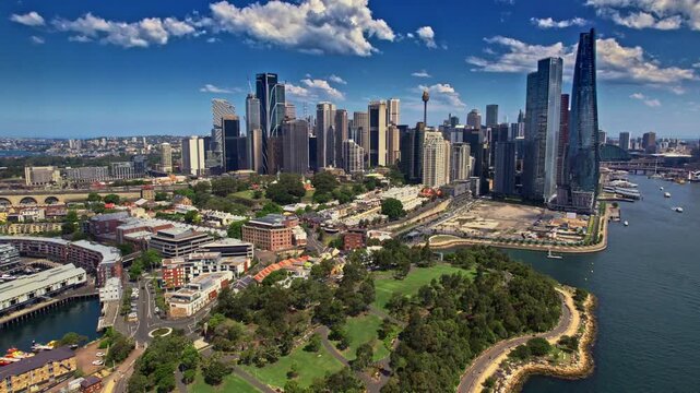 Cityscape With Water, Modern City Skyline Reflecting Sunlight Beside Bustling Harbor And Park