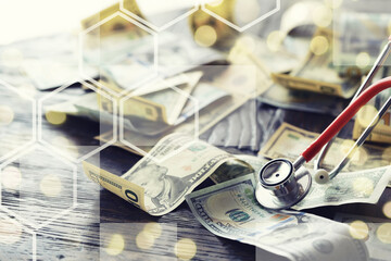 Close up red stethoscope on the US dollar banknote on wooden table. Health check or money and...
