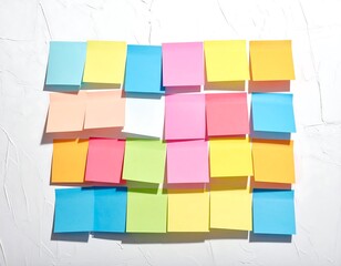 Variety of vibrant sticky notes neatly arranged on textured white background, casting soft shadows