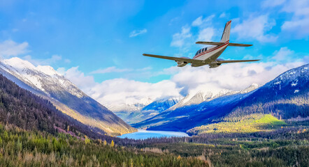 Private Plane Soars Over Snowy BC Mountains Beneath Bright Blue Sky in Stunning Alpine Scene