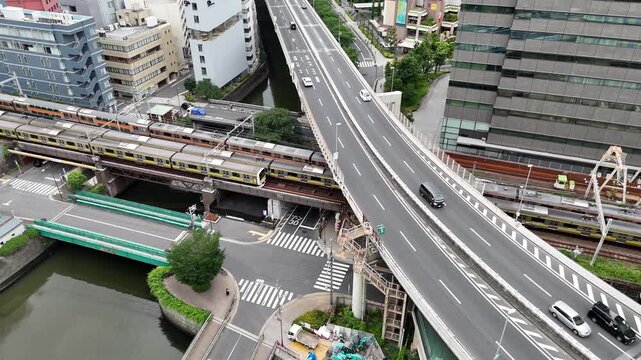 Aerial view of Tokyo urban highway and trains on railway lines along city river