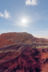 Fototapeta premium Red Rock Desert Landscape Under Bright Sun With Clear Sky And Distant Dunes