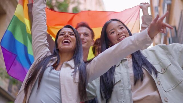 Group of friends celebrating gay pride parade with a rainbow flag