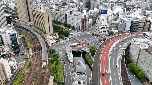 Aerial view of Tokyo expressway, railway lines and canal in dense urban cityscape
