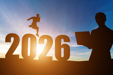 Happy New Year Numbers 2026, Silhouette successful businessman hold laptop and handsome jumping feels happy moving early morning sunrise over the horizon background, Health and Happy new year concept.