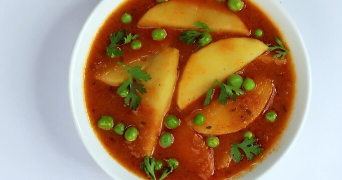 Potato curry or aloo or aaloo masala fry with green peas, indian main course food, selective focus