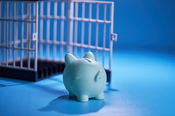 piggy bank about going  in to a cage on blue background