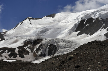 The enchanting beauty of the snowy mountains. The view of snow and rocks on the mountain tops.