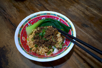 A bowl of ramen noodle, Japanese food with black chopsticks on a wooden table
