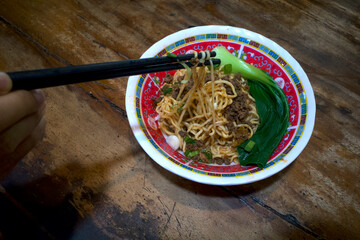 A bowl of ramen noodle, Japanese food with black chopsticks on a wooden table