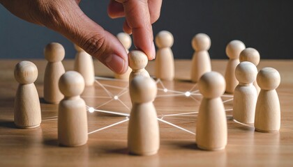 Human hand interacting with wooden network figurines