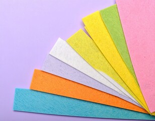 Colorful felt fabric strips fanned out on a lilac background