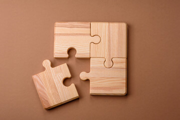 A wooden empty puzzle piece for a sign or business concept. A wooden empty puzzle