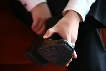 Fototapeta premium Professional business man tying to put on the dress shoes. A professional, stylish business setting with emphasis on detail and refinement of a fine gentlemen