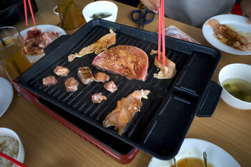 Steak meat with spices and oil on a black grill grate