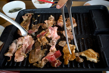 Steak meat with spices and oil on a black grill grate