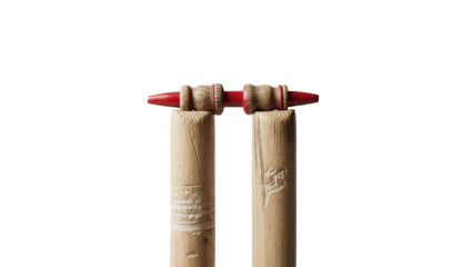 Closeup of two wooden cricket stumps with bright red bails balanced on top, detailed wicket equipment isolated on white background symbolizing dismissal, bowled and run out moments

