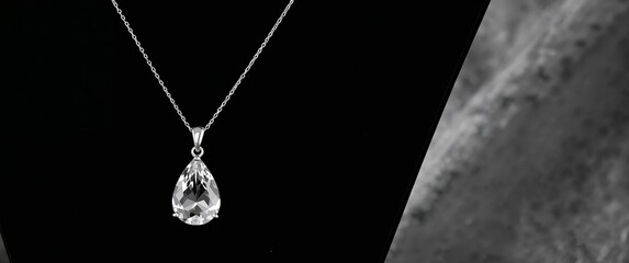 Radiant Teardrop Pendant Silver Chain with Sparkling Gemstone on Dark Background.