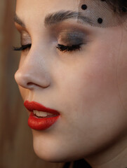 Fototapeta premium A woman with red lipstick and a black hat