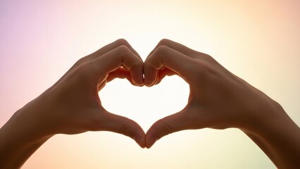 Fototapeta premium Hands forming a heart shape against a bright, colorful sky.