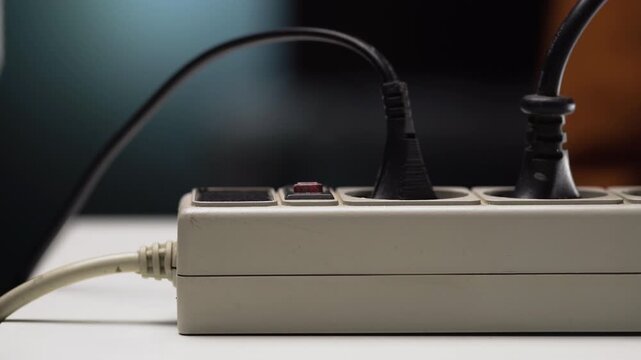 man turns off an electric surge protector. Protection of household appliances. Concept of Home safety