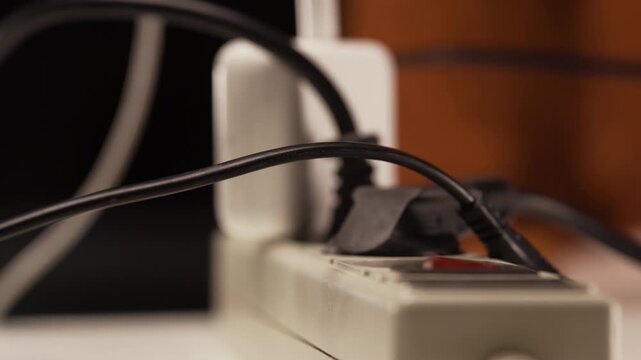 Energy efficiency. Man using electrical plug in outlet socket at home.