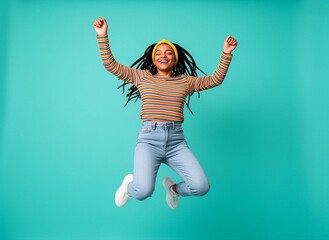 Fototapeta premium A joyful young woman jumping joyfully with her arms raised in celebration