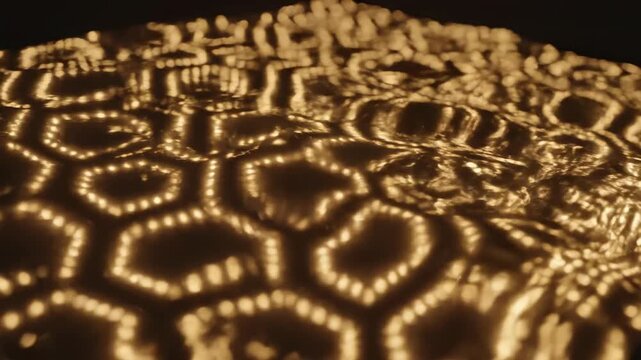 Structured field of warm golden lights arranged in a geometric pattern subtly rippling and distorting like liquid metal on a deep glossy black canvas technology, digital, motion graphics