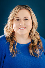 Woman smiling with blonde hair on blue background