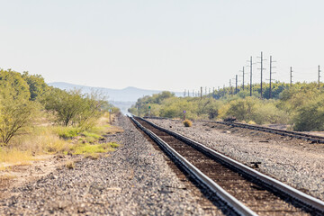 Fototapeta premium Railroad tracks receding away towards horizon desert landscape