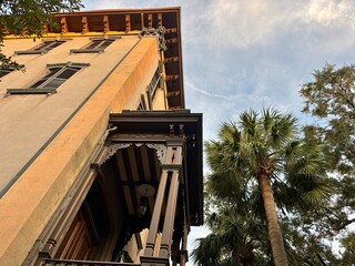 Historic yellow building with ornate dark balconies and palm tree © Cavan