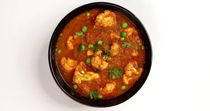 indian spicy food Gobi Masala or gobi fry or cauliflower curry with green peas, served in a bowl, selective focus