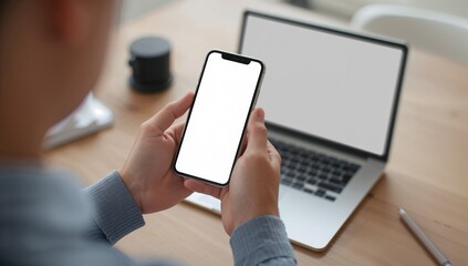 Business workspace scene with hand holding mobile phone and laptop symbolizing productivity remote work and digital connectivity