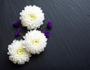 White, small purple flowers on a black stone surface