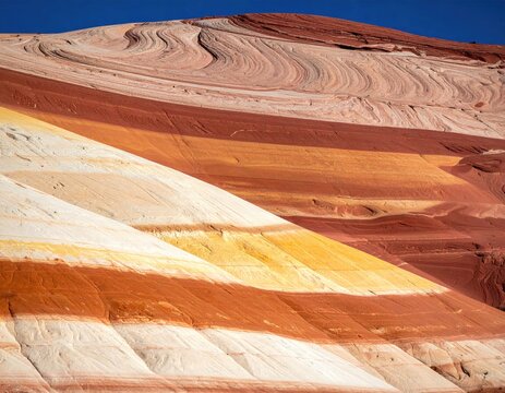 Striated layers of reddish-yellow earth under a clear sky