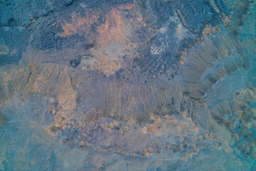 Toxic industrial waste ground with blue and orange sludge, environmental pollution texture and abstract art background, aerial top view drone shot
