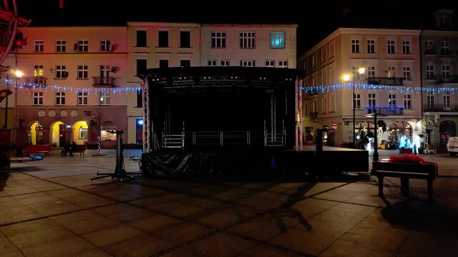 Outdoor stage on market square at night, Christmas illuminations, festive decorations, historic town architecture