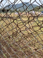 Rusty chainlink fence pattern closeup with abstract background texture.