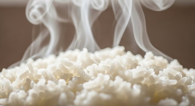 Hot steaming white rice in a bowl with wisps of steam rising.