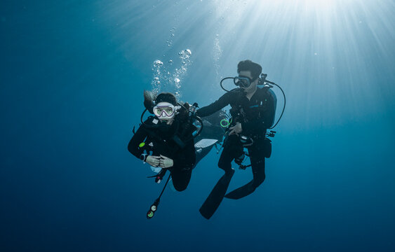 Divemaster assisting novice diver at the Andaman Sea