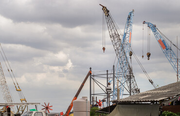 Latticed boom crawler crane of heavy-duty used for rebuilding bridges near the river in Thailand.